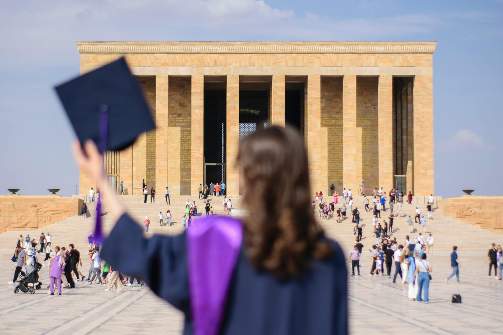 Young woman in graduation attire at Anıtkabir in Ankara, Turkey.
